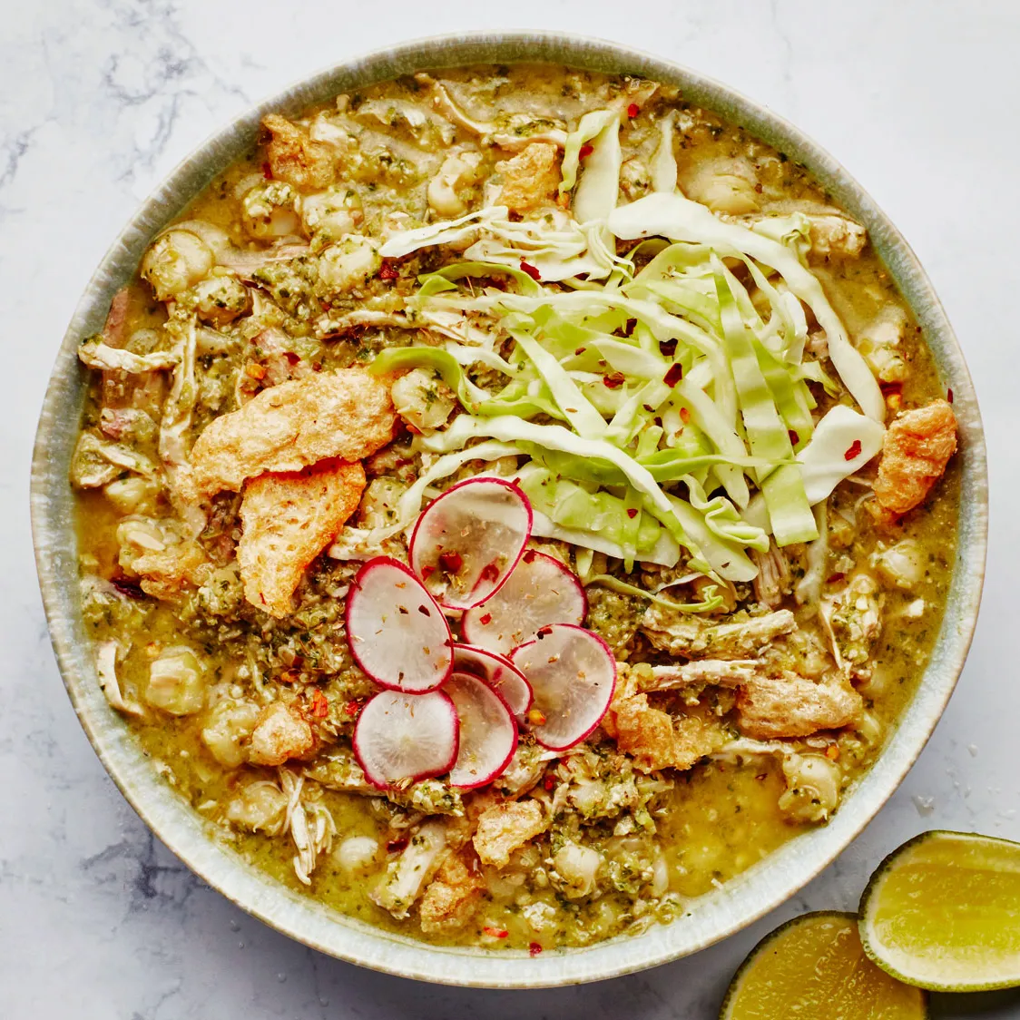 Pozole verde with a vibrant green broth served with tortilla chips