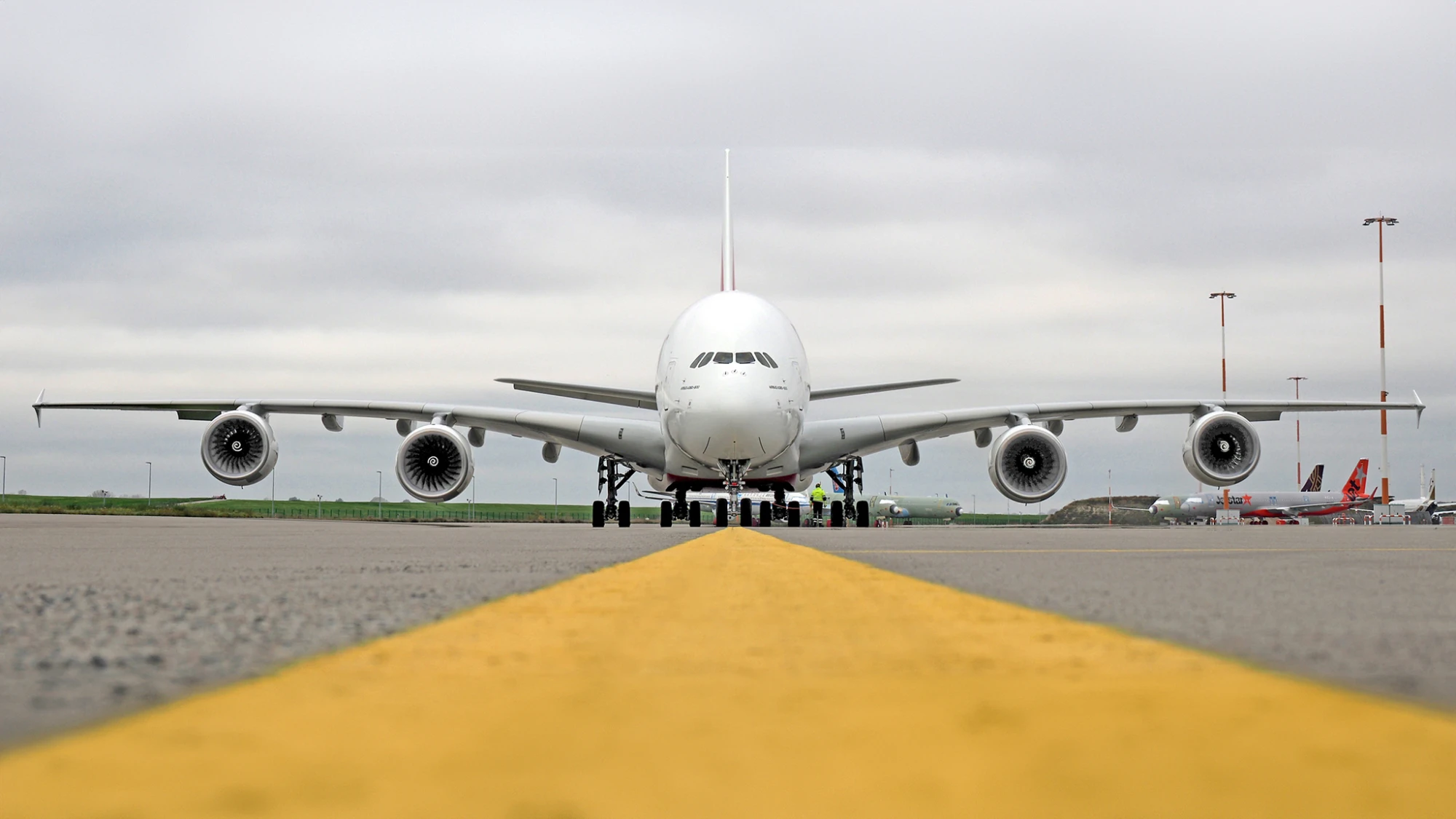 Side view of the Airbus A380 at an airport, showcasing its impressive wingspan. 