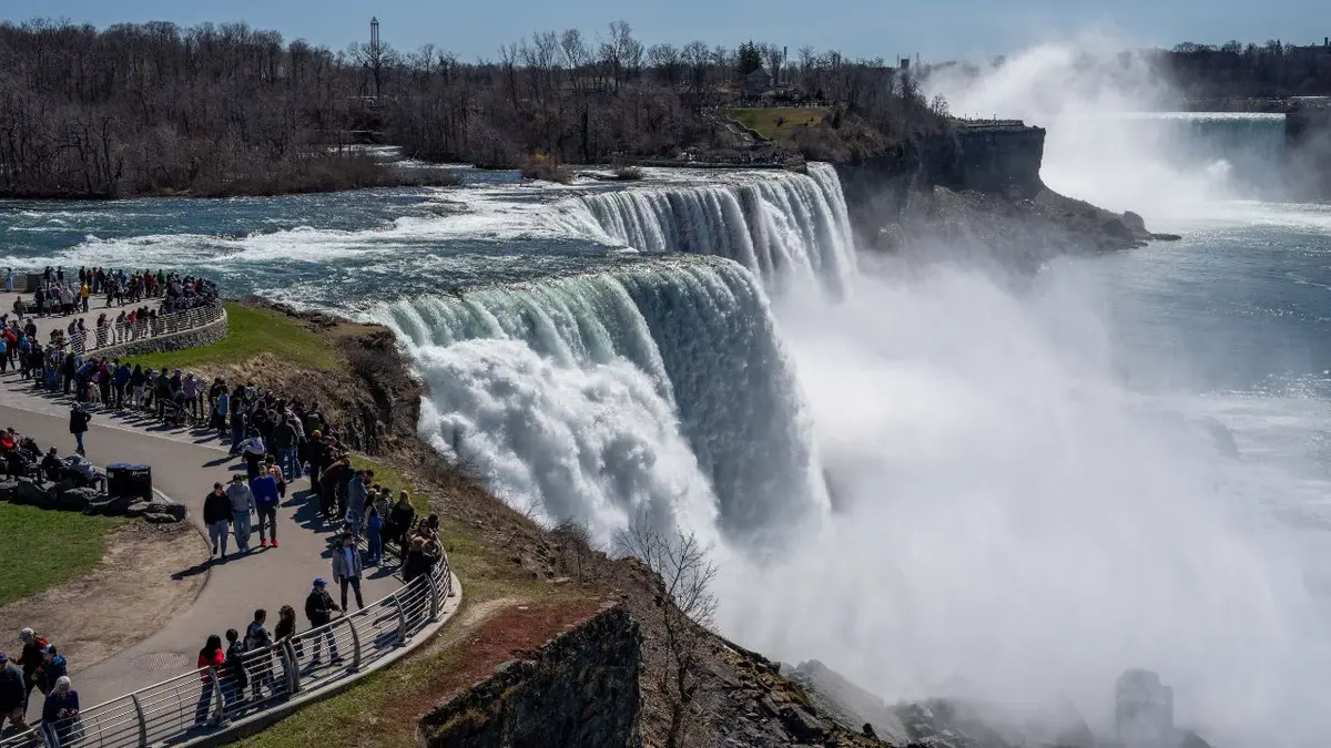 A rainbow arching over Niagara Falls on a sunny day 